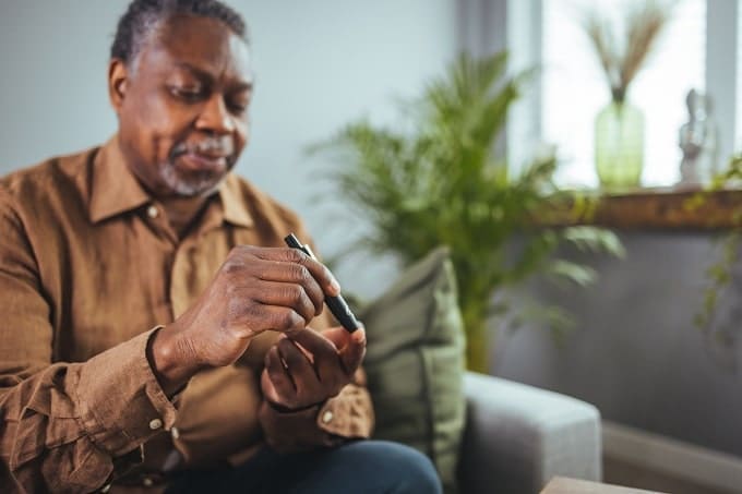 man measuring blood glucose ketones
