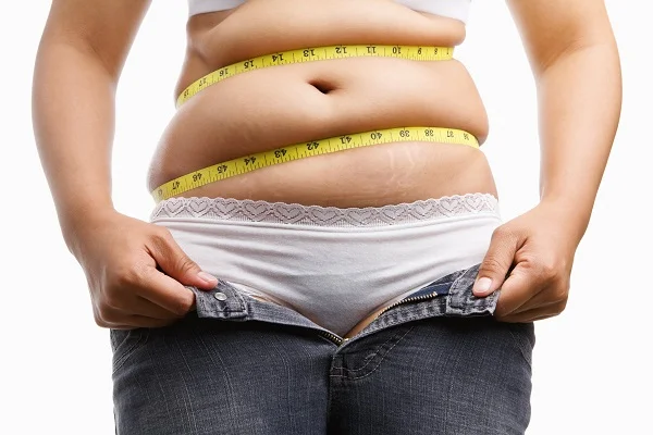 A lady taking the tape measure test for visceral fat