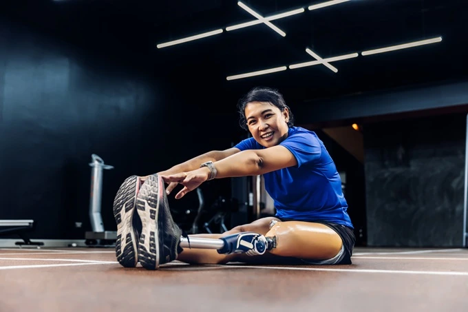 woman with prosthetic leg stretching muscle recovery supplements